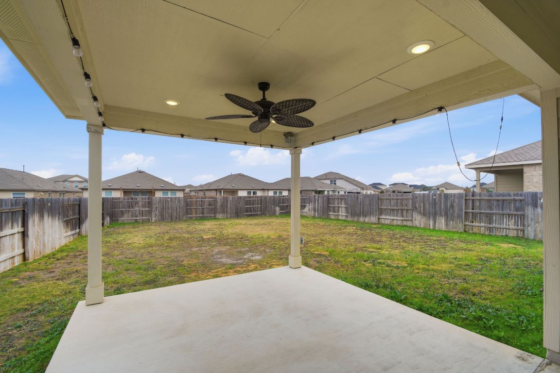 287 George Neggan Lane Bastrop, TX 78602 - Photo 26 of 26 a view of a patio with a table chairs under an umbrella