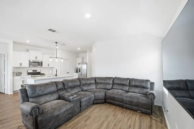 a living room with furniture white walls and kitchen view