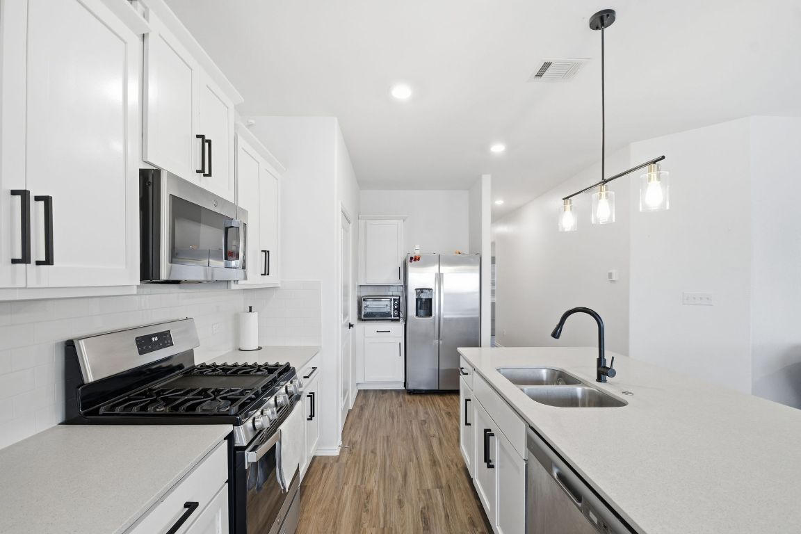 287 George Neggan Lane Bastrop, TX 78602 - Photo 9 of 26 a kitchen with refrigerator a stove and a sink
