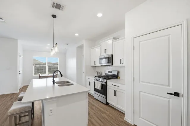 a kitchen with stainless steel appliances a sink stove and refrigerator