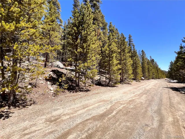 a view of a yard with wooden fence