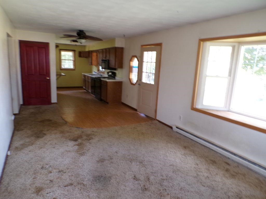 5779 Town Line Road Leaf River, IL 61047 - Photo 2 of 14 an empty room with windows a fireplace and windows