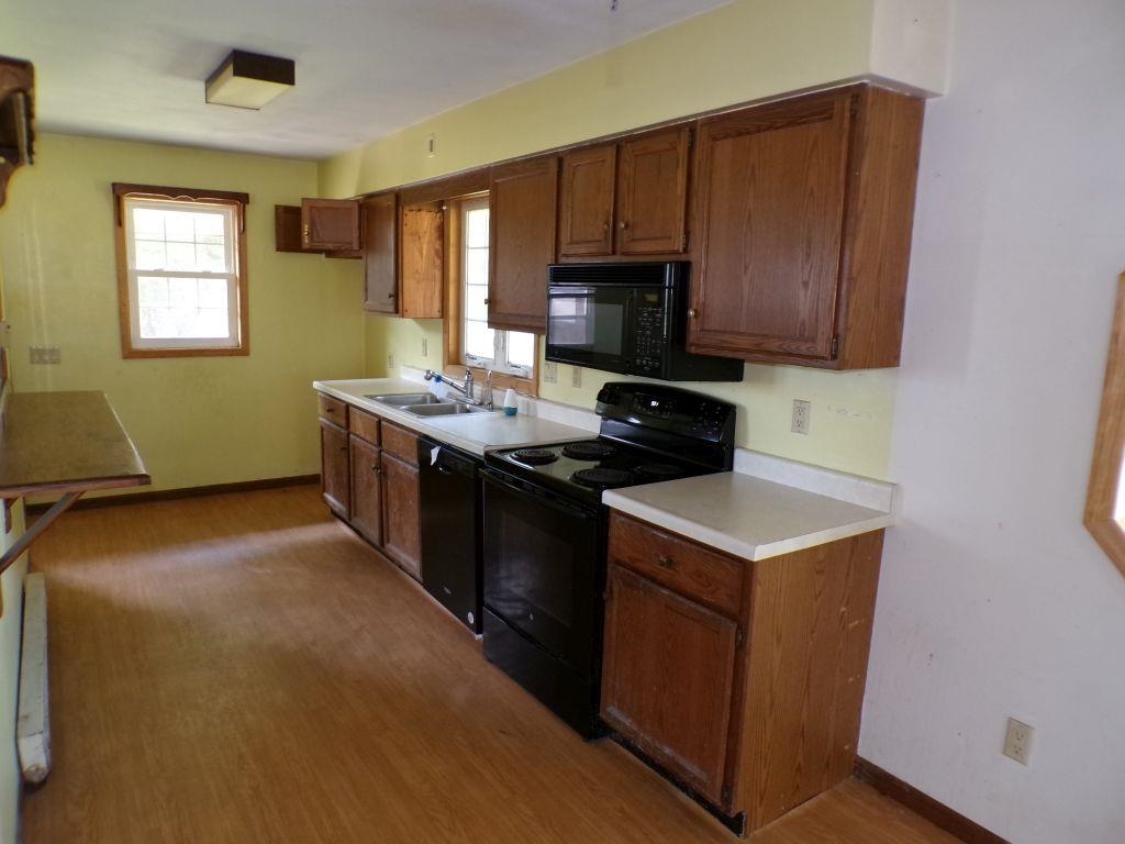 5779 Town Line Road Leaf River, IL 61047 - Photo 4 of 14 a kitchen with stainless steel appliances a stove a microwave a sink a refrigerator and cabinets