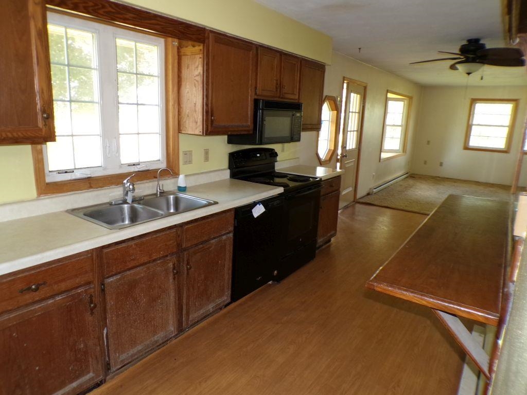 5779 Town Line Road Leaf River, IL 61047 - Photo 5 of 14 a kitchen with stainless steel appliances granite countertop a sink stove and cabinets