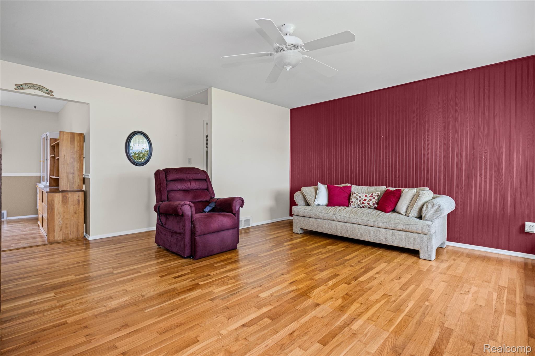 Hardwood flooring throughout, featuring a distinctive accent wall with vertical paneling