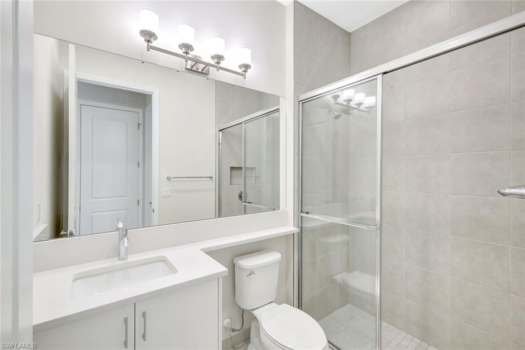21023 Teak Tree Terrace Estero, FL 33928 - Photo 15 of 21 a bathroom with a sink toilet vanity and shower