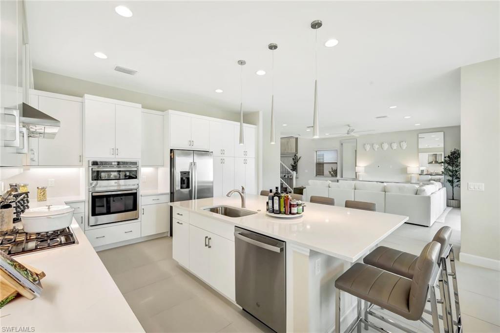 21023 Teak Tree Terrace Estero, FL 33928 - Photo 4 of 21 a kitchen with a sink a stove and chairs