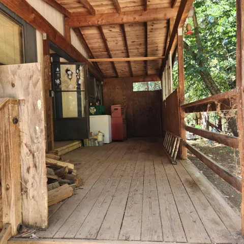 a view of a porch with wooden floor and iron stairs