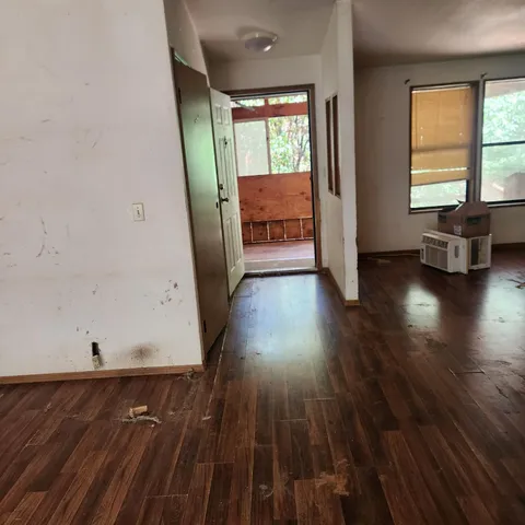 wooden floor in an empty room with a window