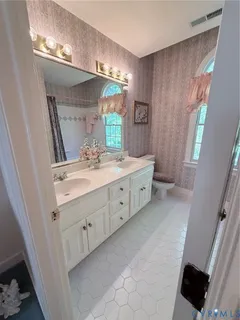 a spacious bathroom with a double vanity sink and a mirror