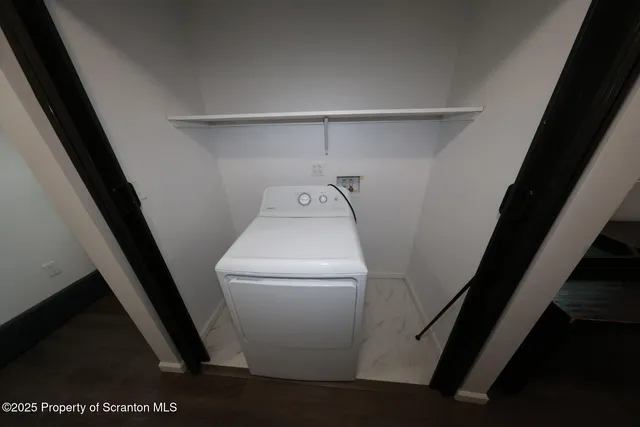 a view of a small space with wooden floor and a window