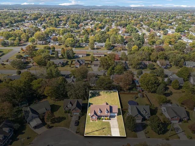 an aerial view of residential building with parking and yard