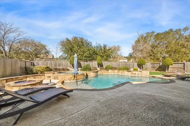 a view of a swimming pool with lounge chairs in patio