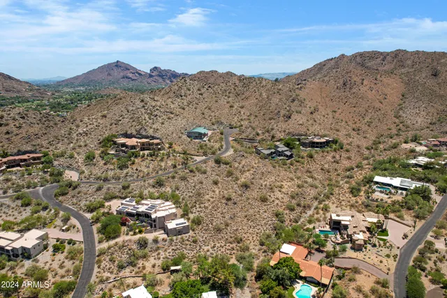 a view of a dry field with mountains in background