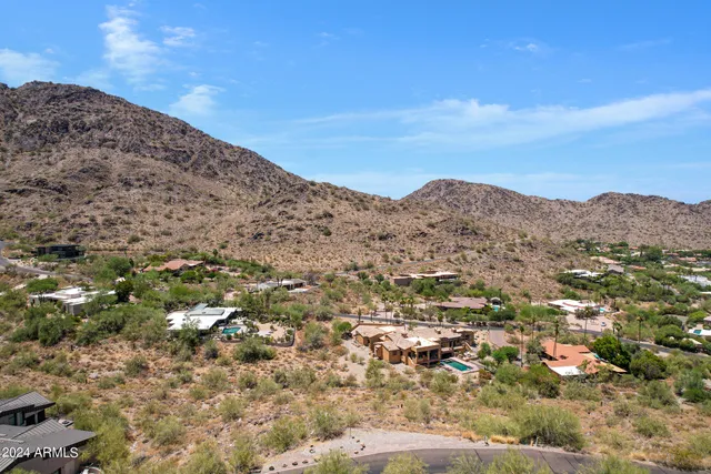 a view of a dry field with mountains in the background