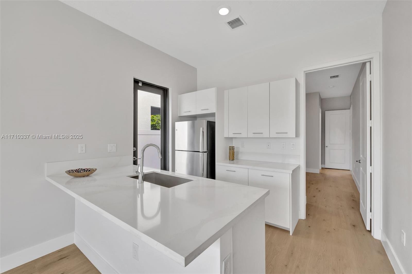 17473 Southwest 41st Street Miramar, FL 33029 - Photo 22 of 92 Guest area for in-laws, next gen, nanny or college student with a bedroom, mini lounge area with refrigerator (2 exterior entrances) & counter seating, laundry machines and bathroom (view toward the bedroom suite of the guest area)