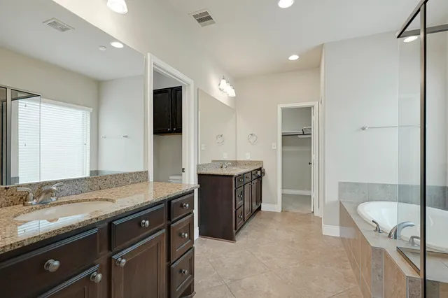 a bathroom with a tub shower and sink