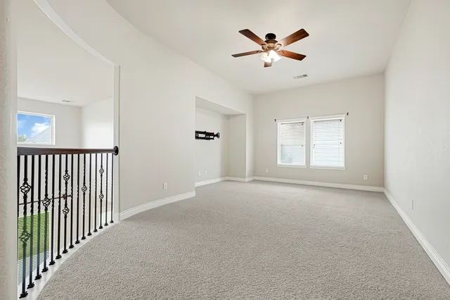 an empty room with a window and a ceiling fan