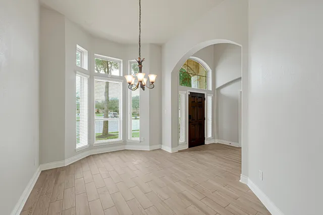 a view of a room with wooden floor chandelier and glass door