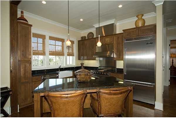 282 Blue Mountain Road Santa Rosa Beach, FL 32459 - Photo 4 of 16 a kitchen with a refrigerator a sink and wooden cabinets