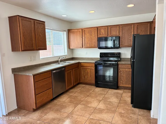 a kitchen with stainless steel appliances granite countertop a stove refrigerator and a sink