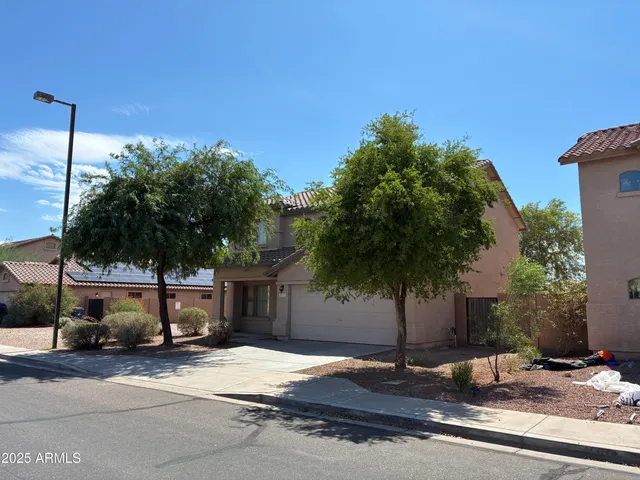 a palm tree sitting in front of a house