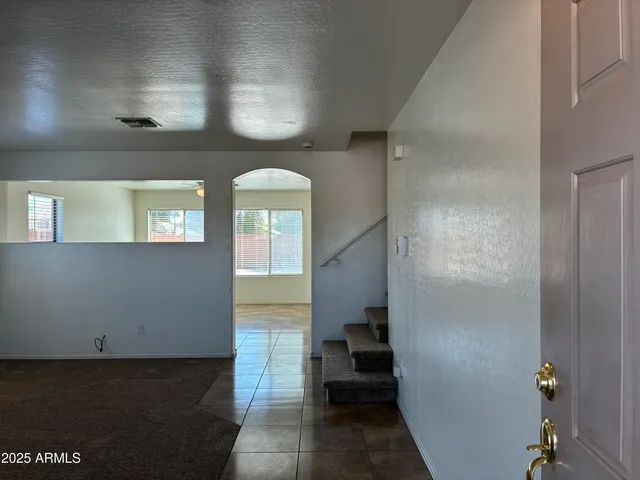 a view of a hallway with wooden floor and a living room