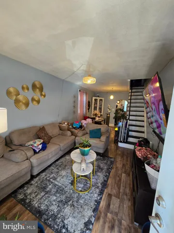 a living room with furniture and a dining table with rug