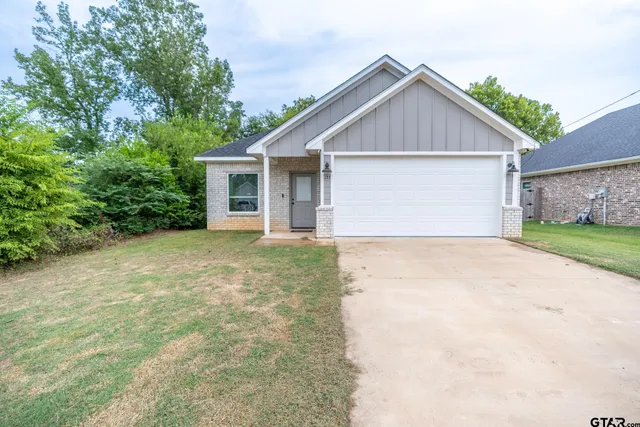 a view of a house with a yard and garage