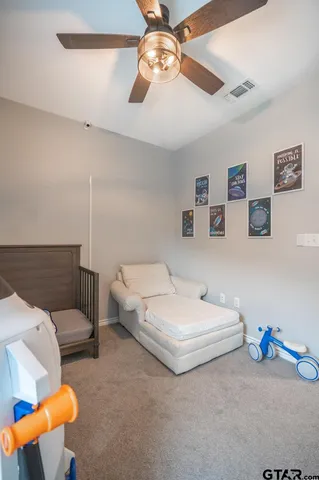 a spacious bedroom with a bed and a chandelier