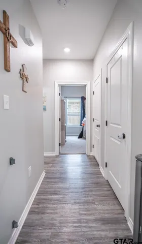 a view of a hallway with wooden floor and closet area