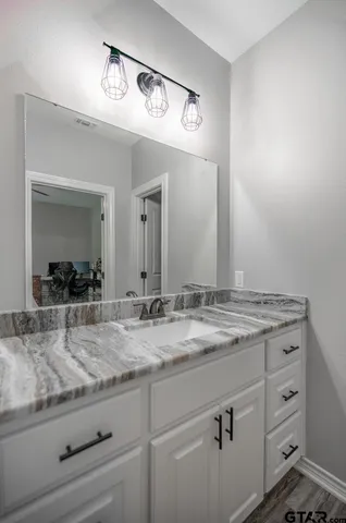 a bathroom with a granite countertop sink and a mirror