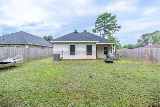 a backyard of a house with table and chairs
