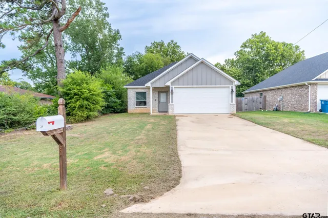 a view of a house with a yard and fence