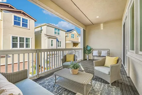 a view of a patio with couches chairs and wooden floor