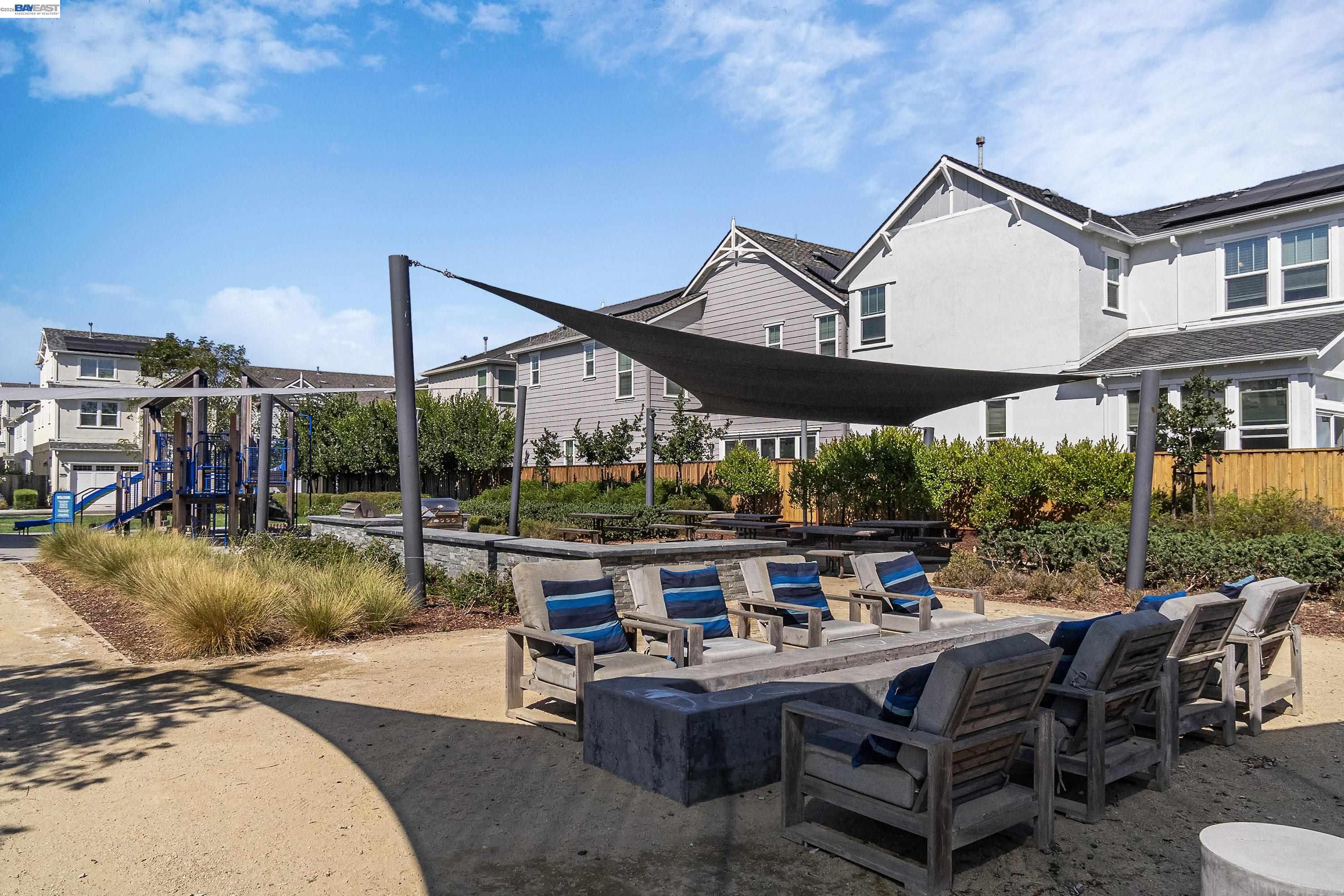 37541 Bay Crest Road Newark, CA 94560 - Photo 47 of 50 a view of a patio with couches table and chairs under an umbrella