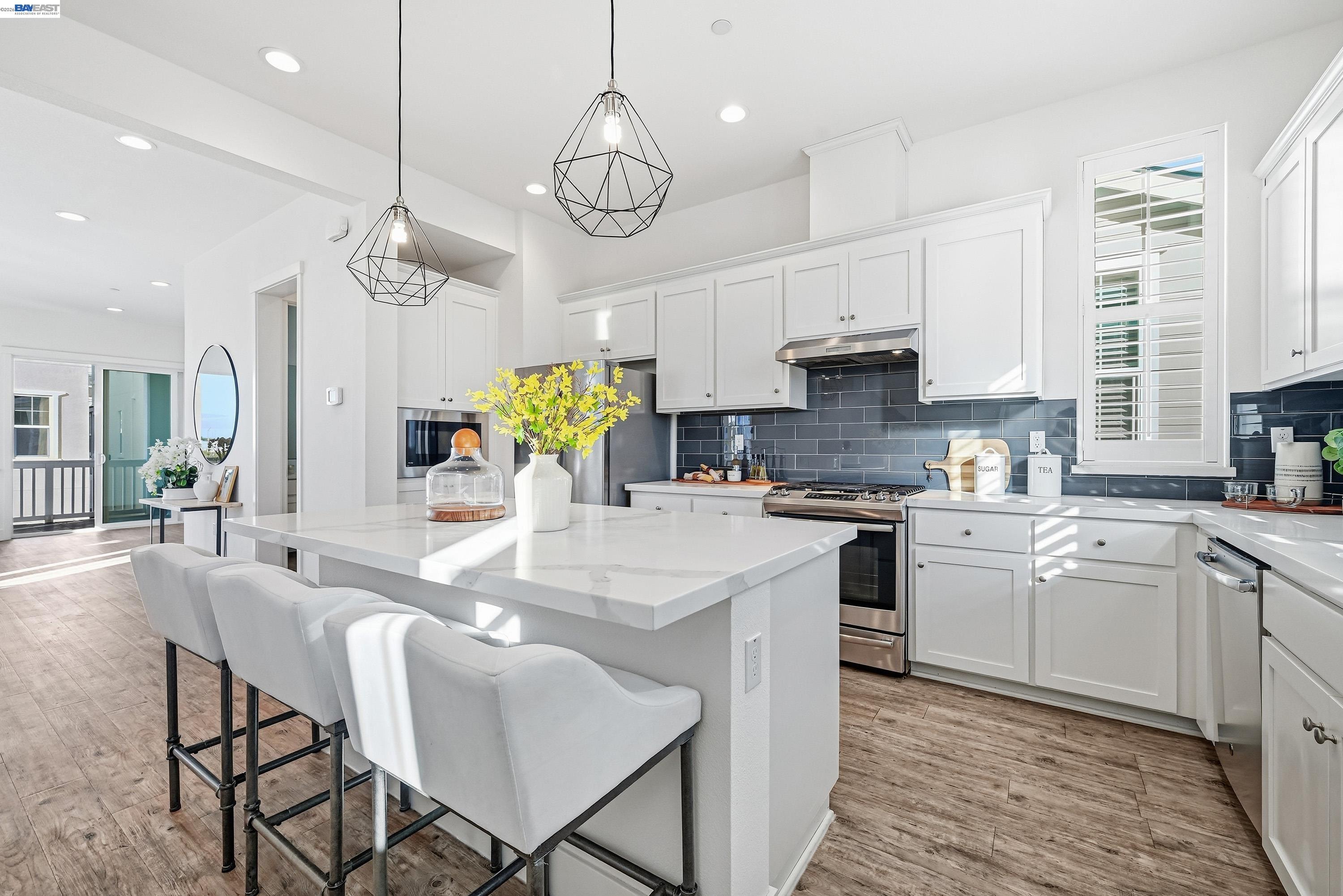 37541 Bay Crest Road Newark, CA 94560 - Photo 8 of 50 a kitchen with stainless steel appliances granite countertop a stove a sink dishwasher a dining table and chairs with wooden floor