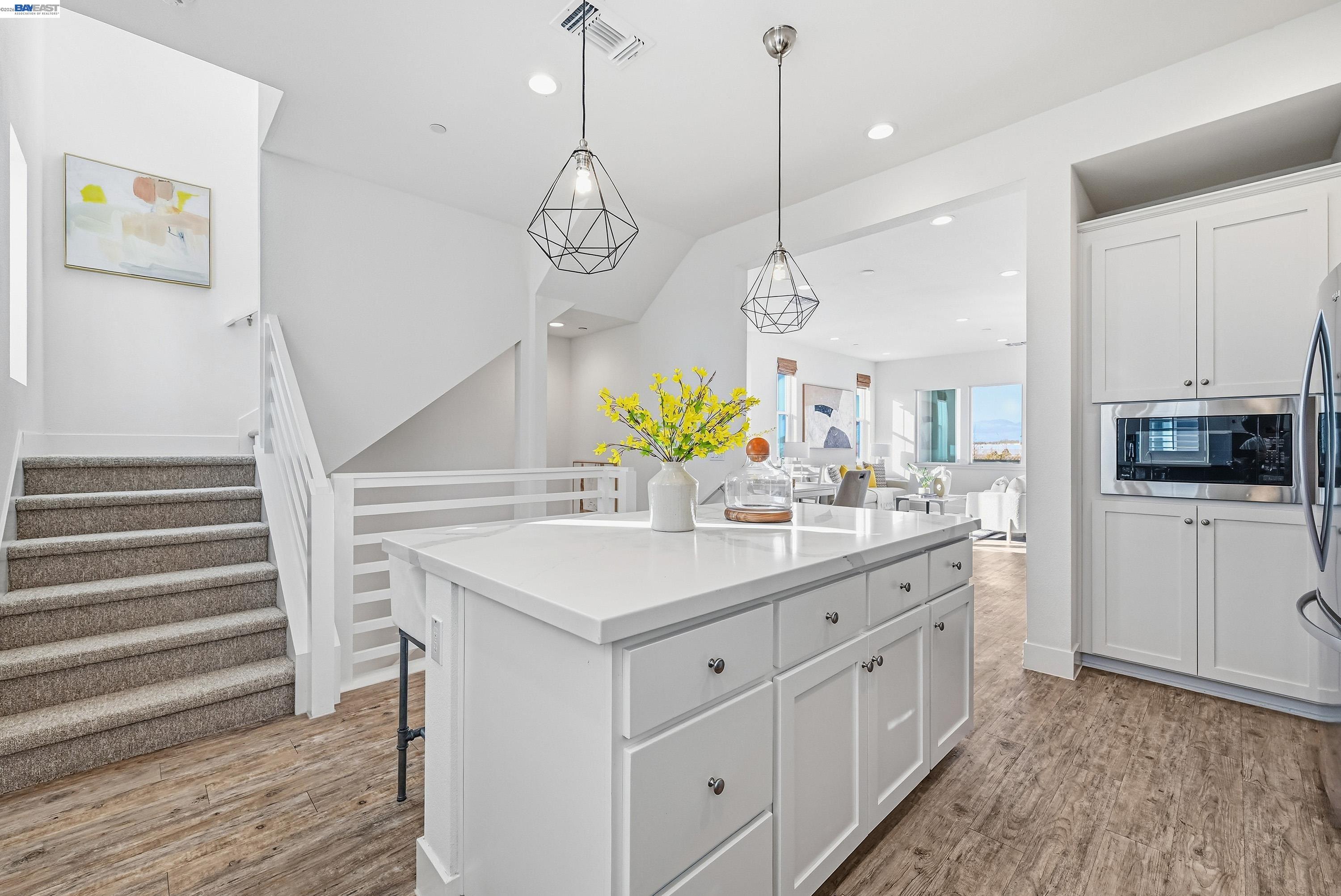 37541 Bay Crest Road Newark, CA 94560 - Photo 10 of 50 a kitchen with a sink dishwasher a dining table and chairs with wooden floor
