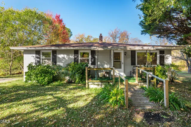 a view of a house with porch and garden