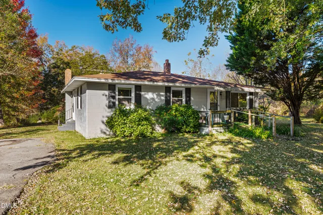 a view of a house with a yard and potted plants