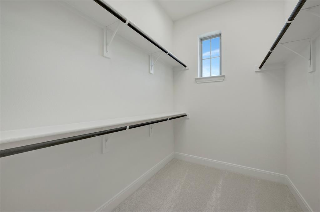 1908 Cola Drive Van Alstyne, TX 75495 - Photo 11 of 29 Spacious walk-in closet featuring light gray carpeting, white walls, and a single window providing natural illumination