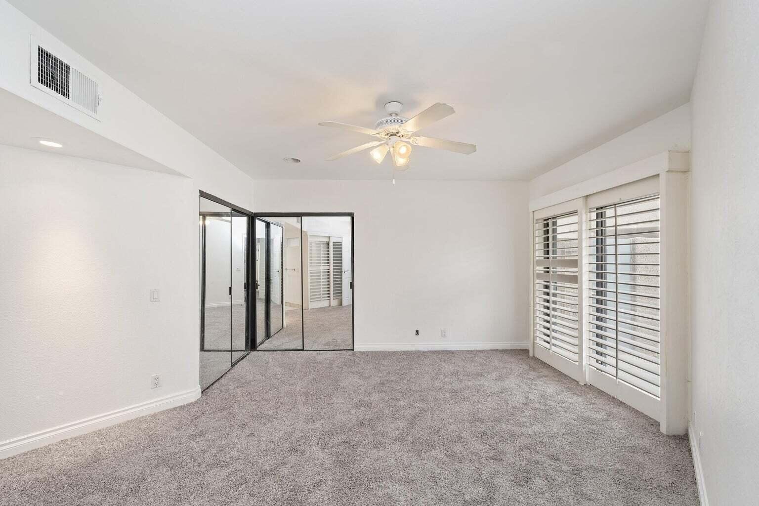 71861 Eleanora Lane Rancho Mirage, CA 92270 - Photo 9 of 22 an empty room with chandelier fan and windows