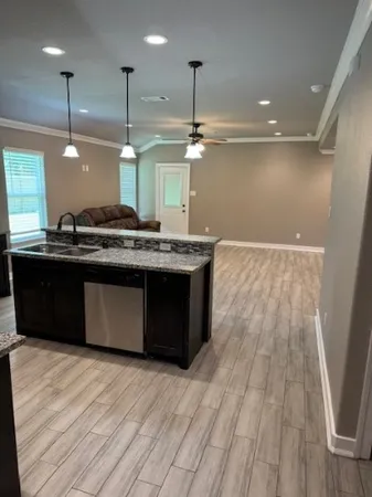 a kitchen with stainless steel appliances granite countertop a sink a stove and a wooden floors