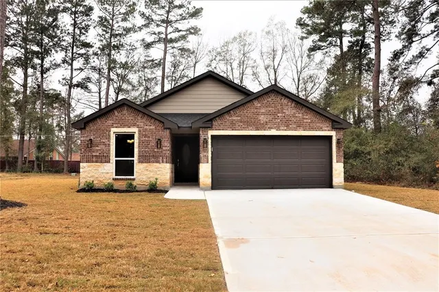 a front view of a house with yard and garage