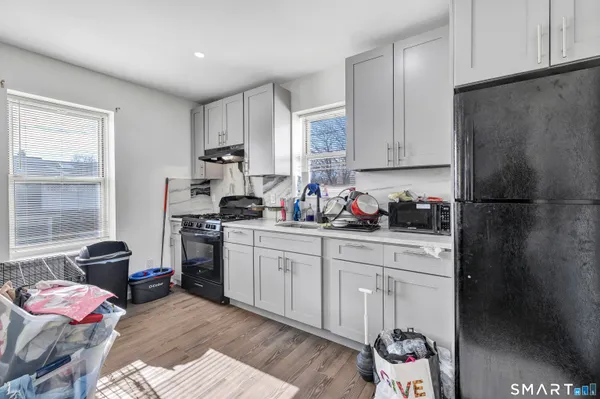a kitchen with a refrigerator and white cabinets