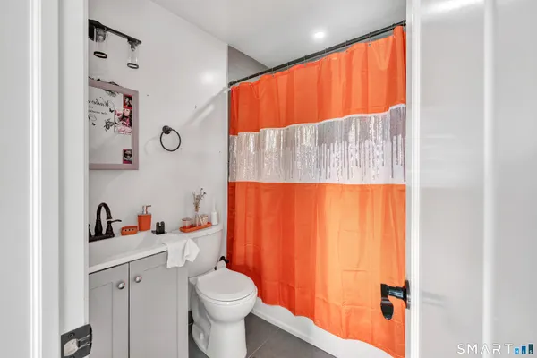 a white toilet sitting next to a bathroom sink and vanity