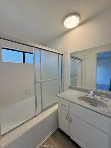 a bathroom with a granite countertop sink mirror and a bathtub