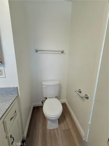 a white toilet sitting next to a white sink and vanity