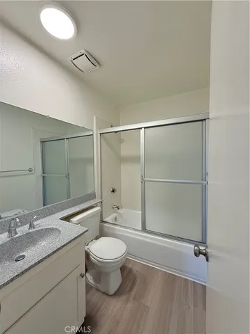 a bathroom with a granite countertop sink toilet a mirror and shower
