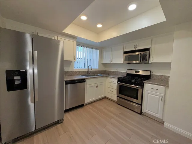 a kitchen with stainless steel appliances a refrigerator stove and microwave